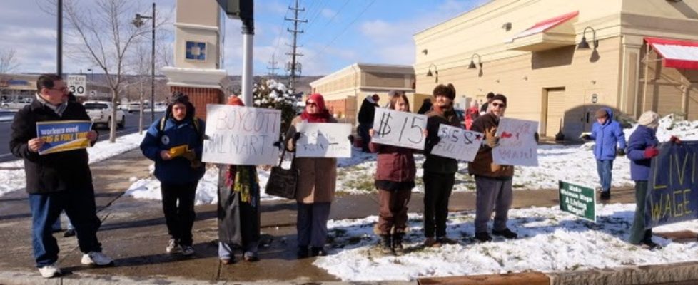 Citizens concerned with the downward spiral taken by global corporations to dismantle our economy stand in front of the Ithaca Wal-Mart on Black Friday to bring attention to Wal-Marts egregious actions. (Photo: Paul Gottleib)